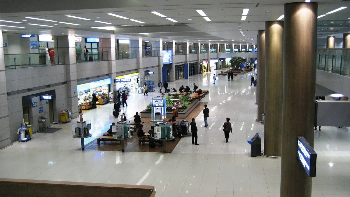 仁川国際空港の到着ロビーを上階から見た様子。売店やベンチが並ぶ広い通路